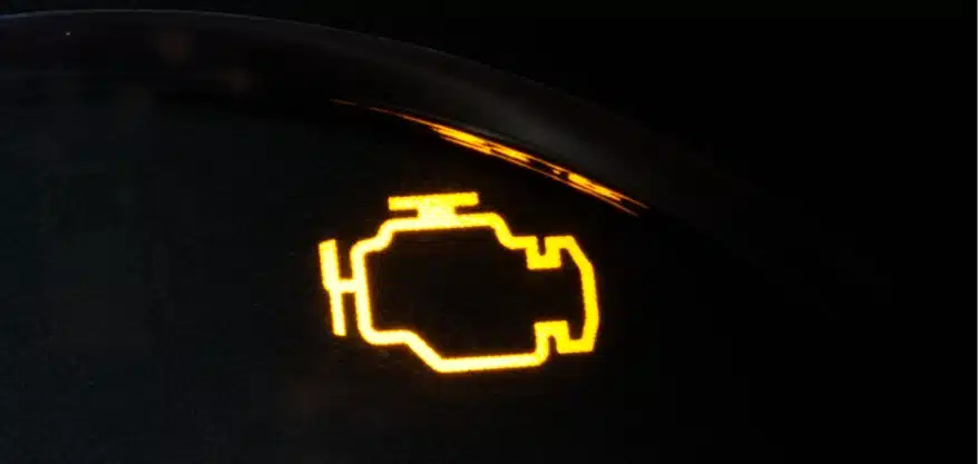 Warning light testing in Grawn, MI at Integrity Import Service. A yellow check engine light symbol is illuminated on a dark automotive dashboard display.